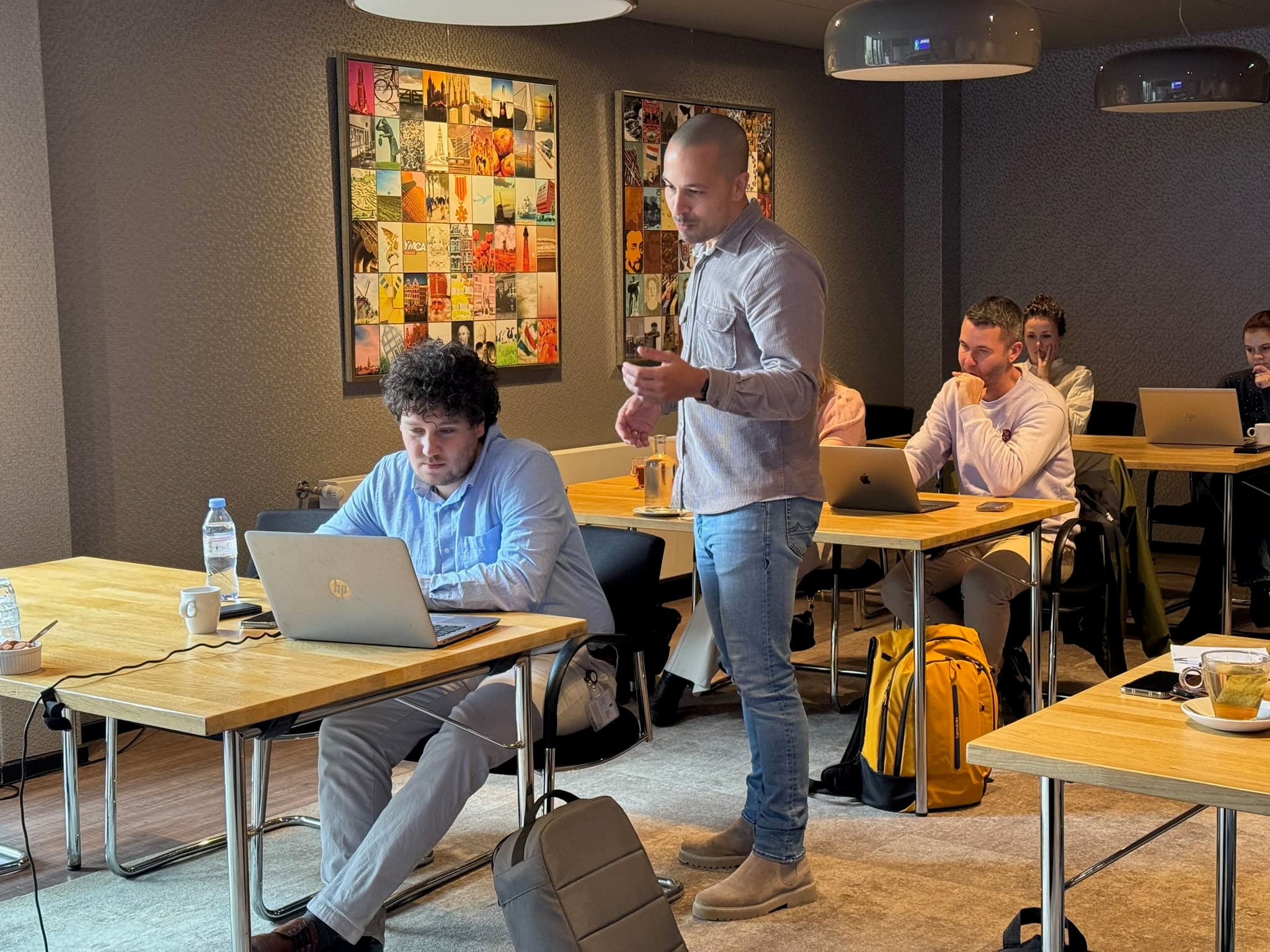Trainer helpt een deelnemer aan zijn laptop